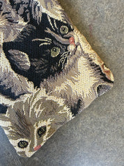 Close up to show design of bag with cat designs on a concrete background