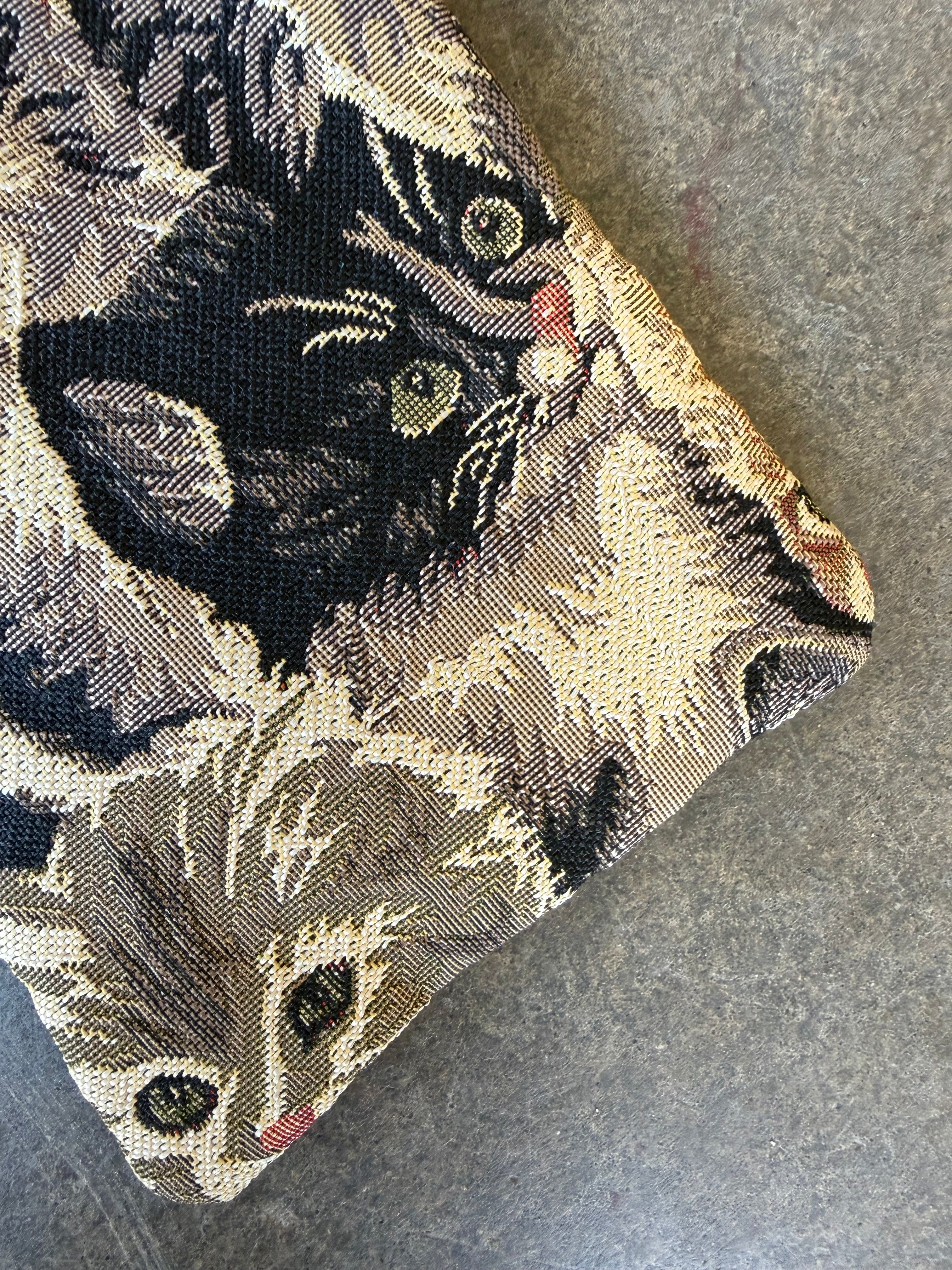Close up to show design of bag with cat designs on a concrete background