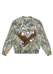 Camouflage sweatshirt with 'American Woman' text and eagle graphic on a white background, flat lay frontal view