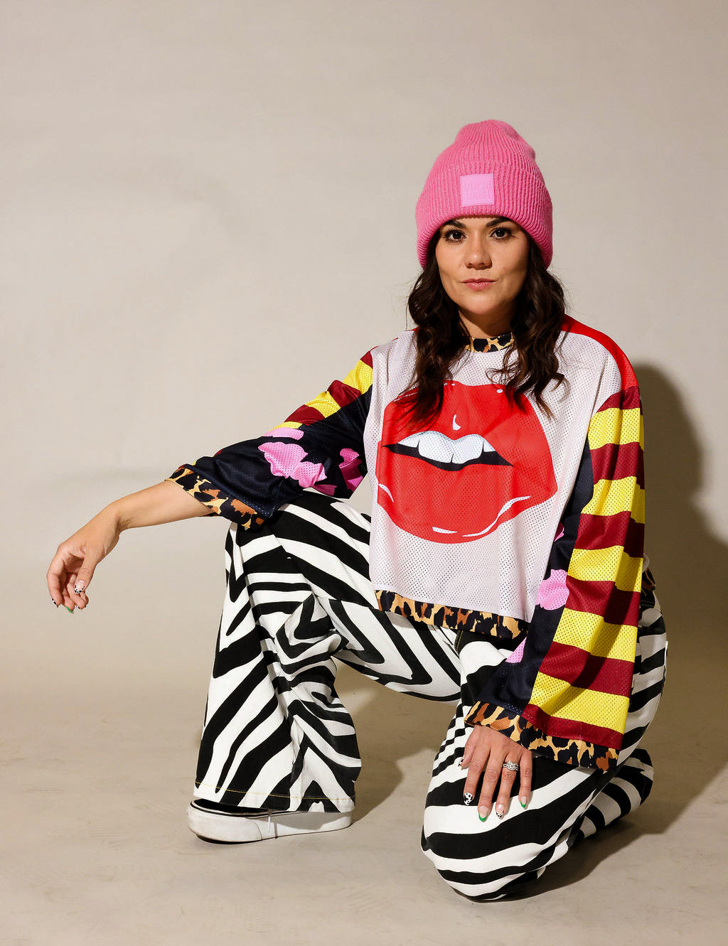 Model wearing close-up of a colorful long sleeve striped mesh jersey, leopard band near waist, black and white zebra, faux denim jeans, frontal view