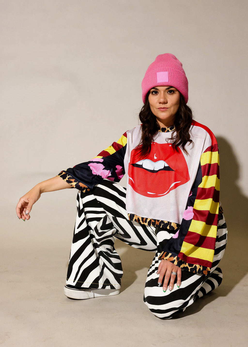Model wearing close-up of a colorful long sleeve striped mesh jersey, leopard band near waist, black and white zebra, faux denim jeans, frontal view