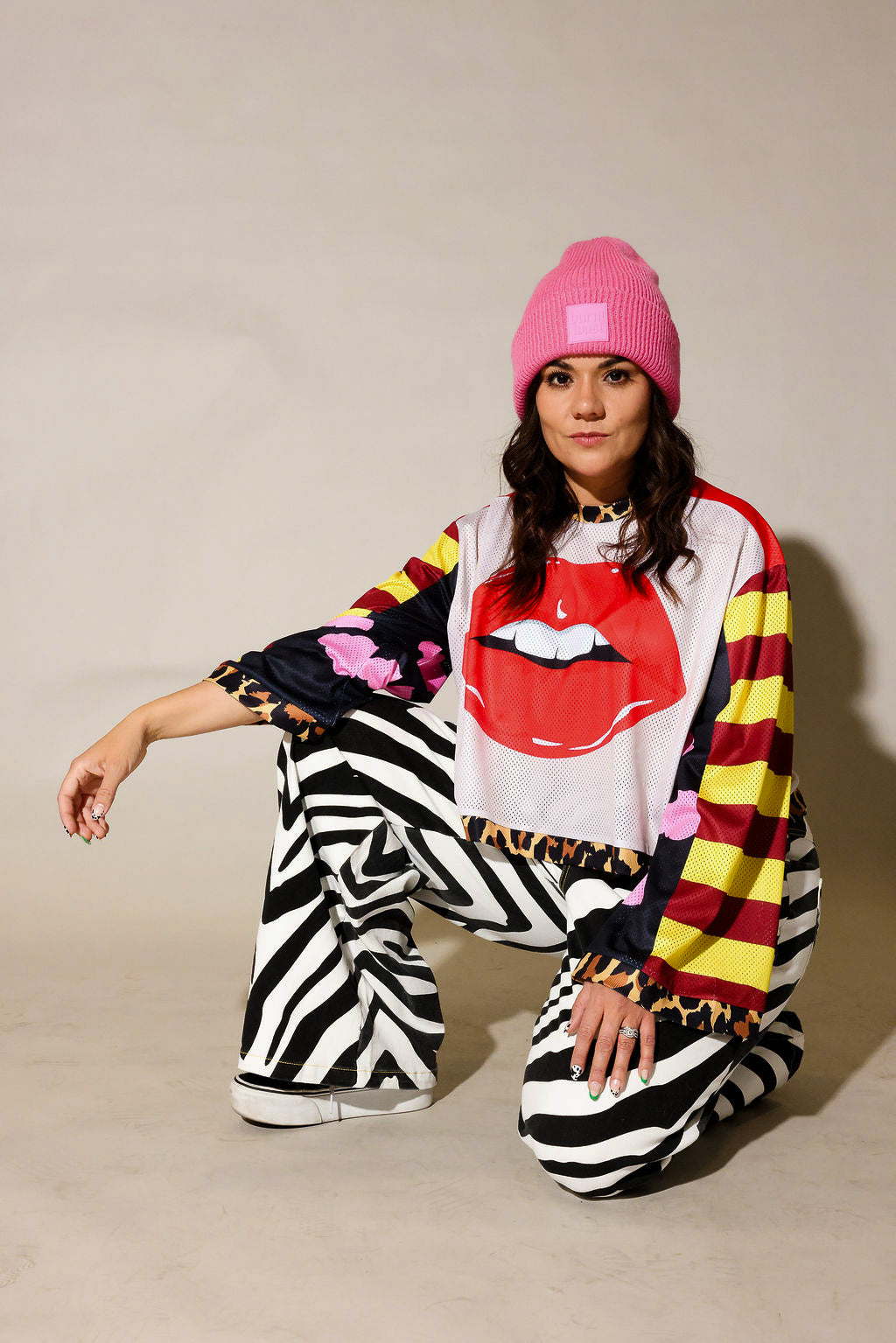 Model wearing close-up of a colorful long sleeve striped mesh jersey, leopard band near waist, black and white zebra, faux denim jeans, frontal view