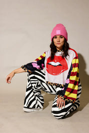 Model wearing close-up of a colorful long sleeve striped mesh jersey, leopard band near waist, black and white zebra, faux denim jeans, frontal view