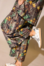 Model wearing a camouflage ribbed short sleeve and pant set, on a beige background, close up side view