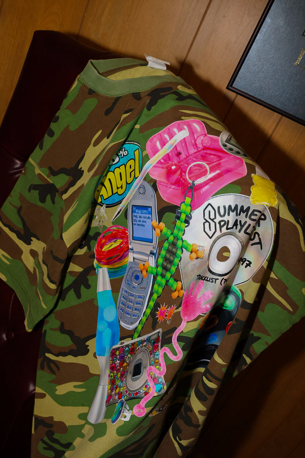 Camouflage-patterned bag with colorful decorations on a wooden surface