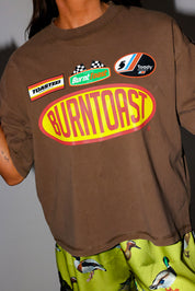 Model wear brown shirt with BURNT TOAST logo and green satin shorts, close up frontal view
