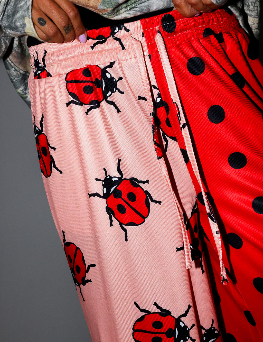 Pink pants with ladybug pattern and red pants with black polka dots. close up frontal view