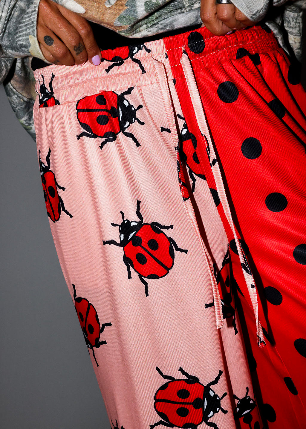 Pink pants with ladybug pattern and red pants with black polka dots. close up frontal view