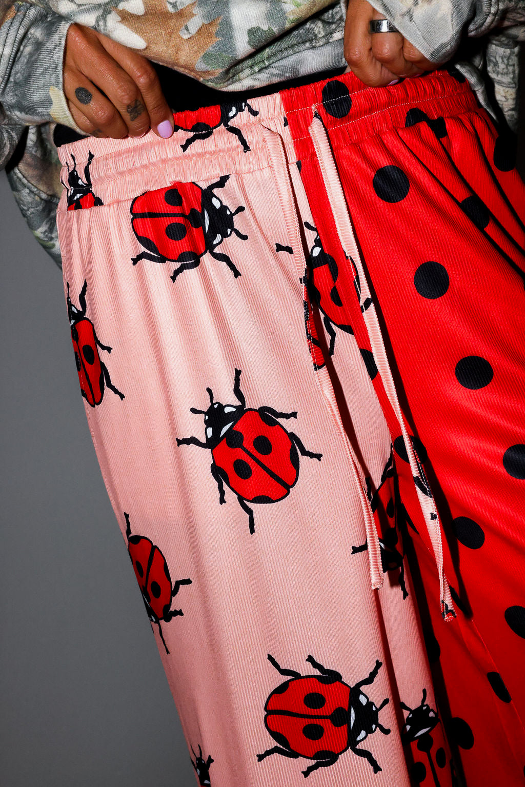 Pink pants with ladybug pattern and red pants with black polka dots. close up frontal view