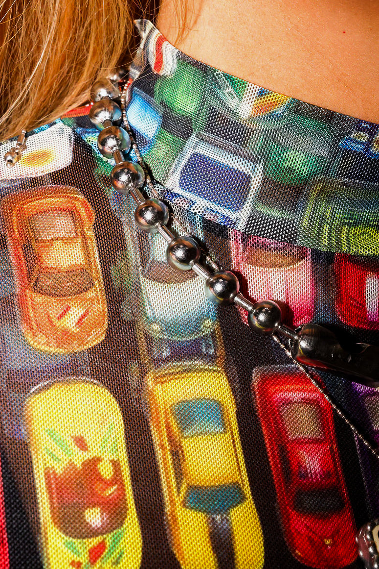 Close-up of a colorful keychain with a long sleeve mesh top, with car designs
