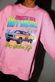 Model wearing a pink crewneck with a colorful graphic of a car and text on a plain background, frontal view