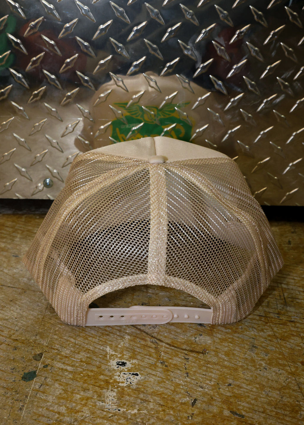 Tan trucker on a textured surface with a metallic background, back view