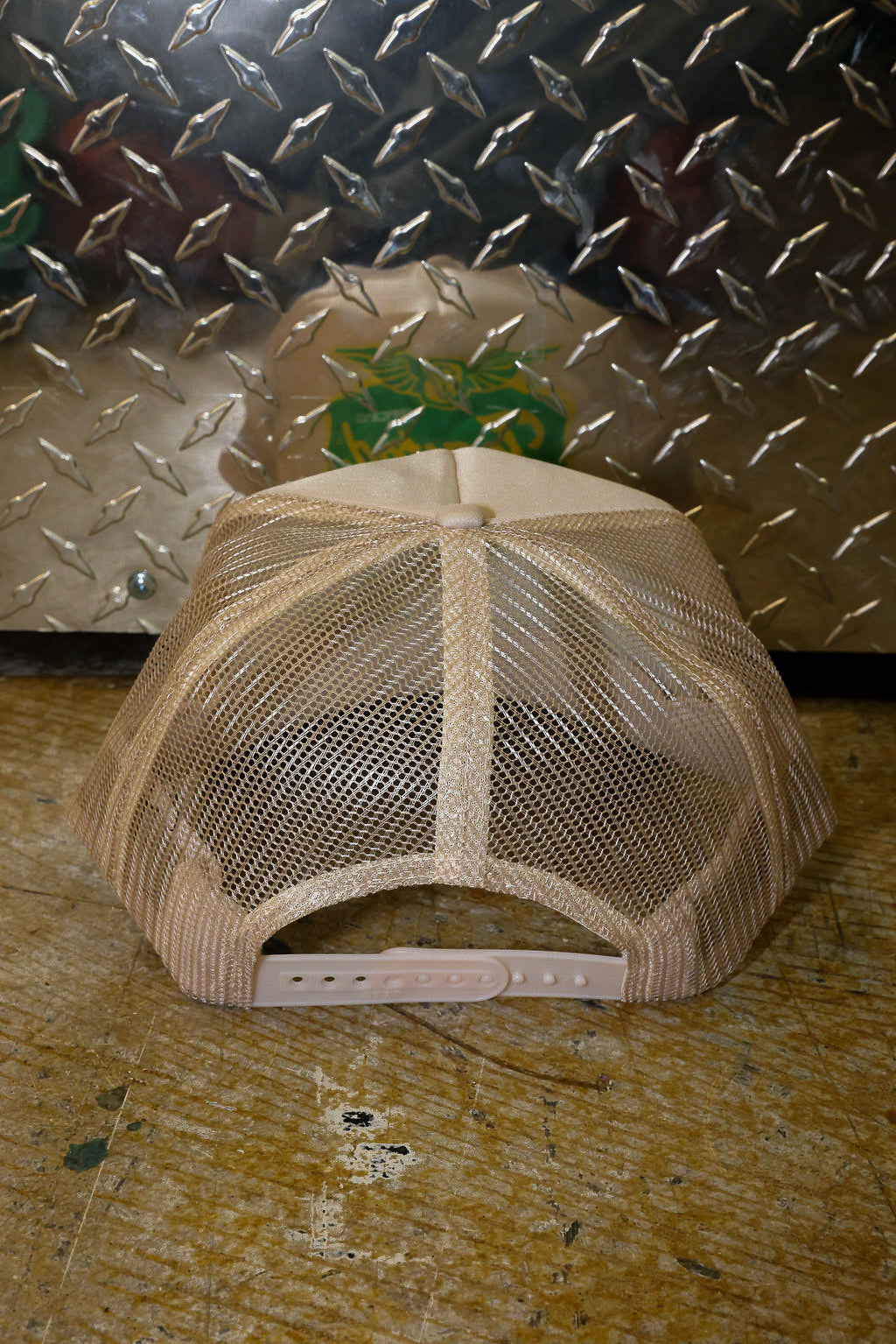 Tan trucker on a textured surface with a metallic background, back view