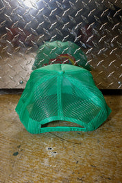 Green mesh trucker on a textured metal surface, back view