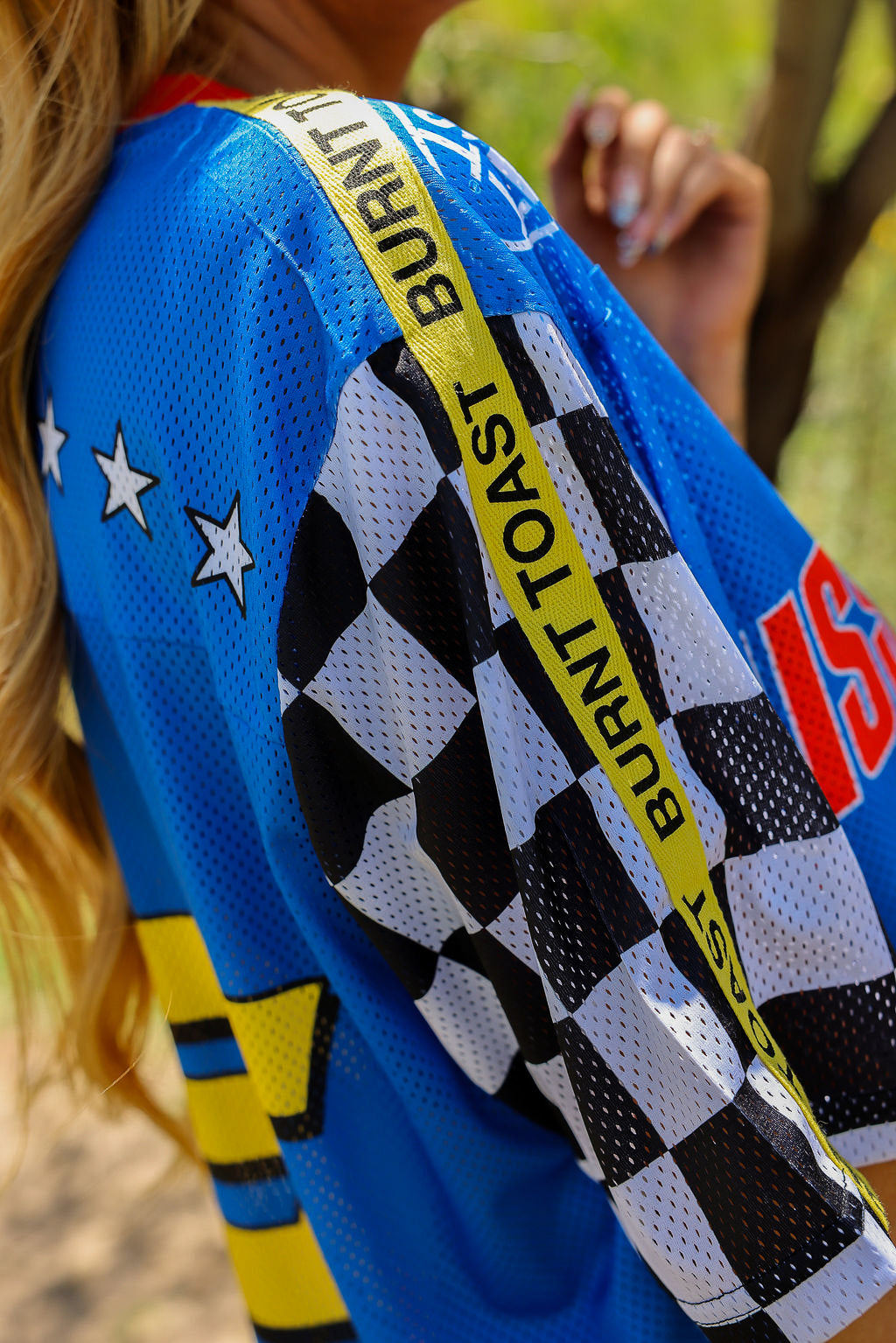 Close-up of a blue racing jersey with checkered pattern and branding, side view