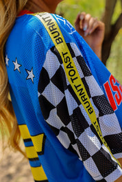 Close-up of a blue racing jersey with checkered pattern and branding, side view