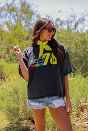 Woman wearing a black t-shirt with colorful design outdoors, frontal view