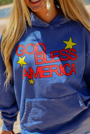 Person wearing a blue hoodie with 'GOD BLESS AMERICA' text and stars, close up view