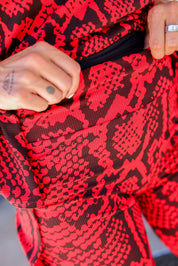 Close-up of a red and black patterned fabric with a hand holding the waistband