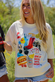 Woman wearing a graphic t-shirt with various designs outdoors, frontal view
