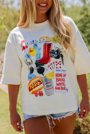 Person wearing a ivory t-shirt with colorful graphic design outdoors, frontal view