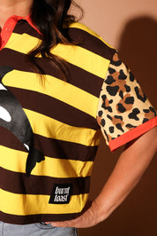 Person wearing a striped shirt with a leopard print sleeve and 'burnt toast' label, close up view