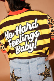 Person wearing a brown and yellow striped shirt with 'No Hard Feelings Baby!' text and leopard print details, back view