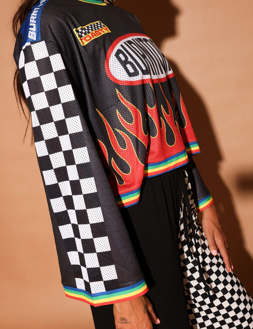 Black long-sleeve mesh jersey with 'Burntoast' logo and flames design, worn by a person, close up side view