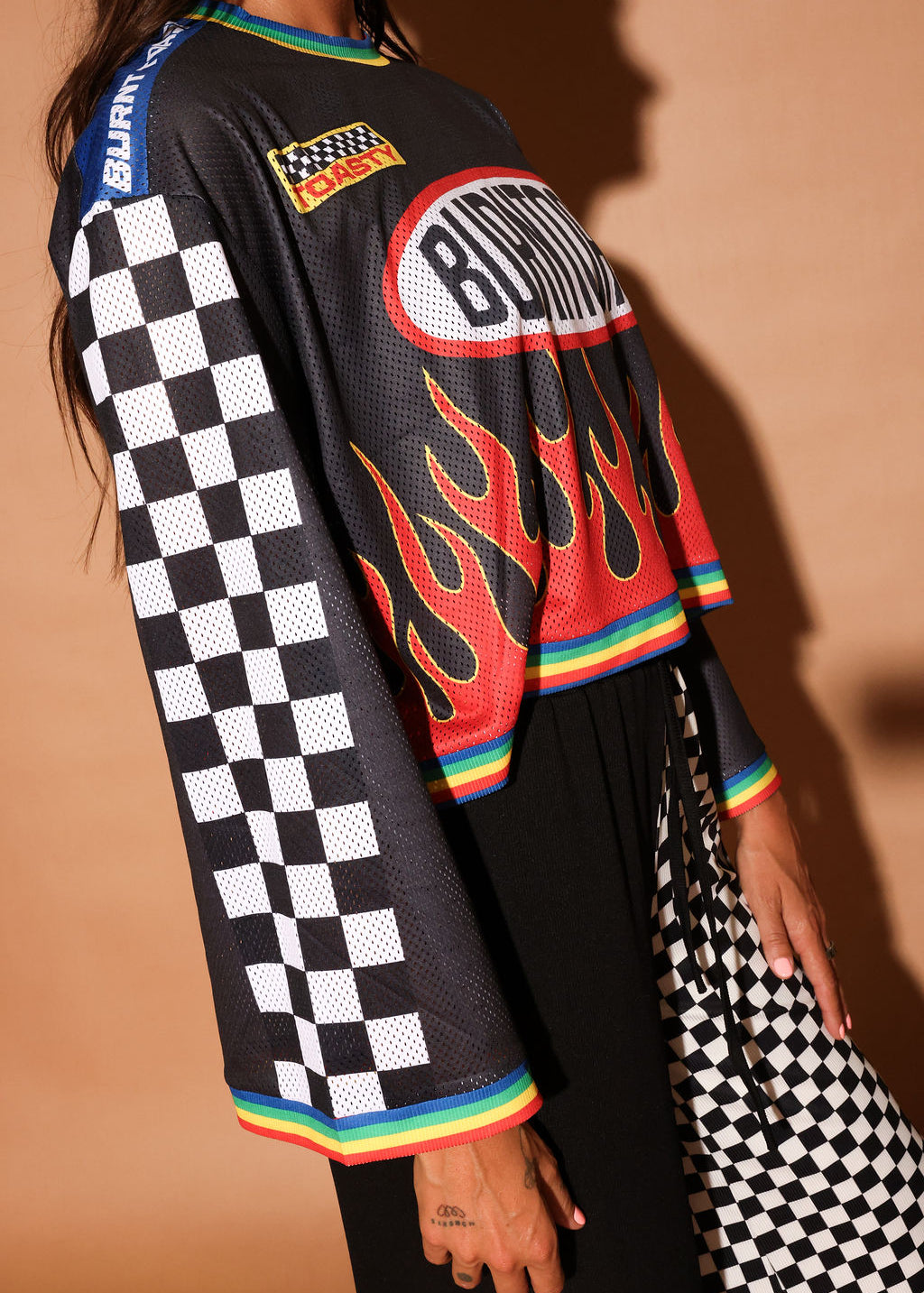 Black long-sleeve mesh jersey with 'Burntoast' logo and flames design, worn by a person, close up side view