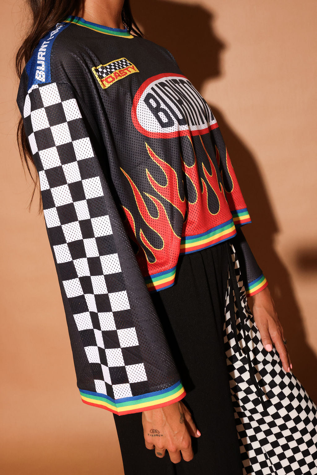 Black long-sleeve mesh jersey with 'Burntoast' logo and flames design, worn by a person, close up side view