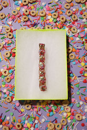 Bracelet on a yellow card with colorful cereal and sprinkles in the background