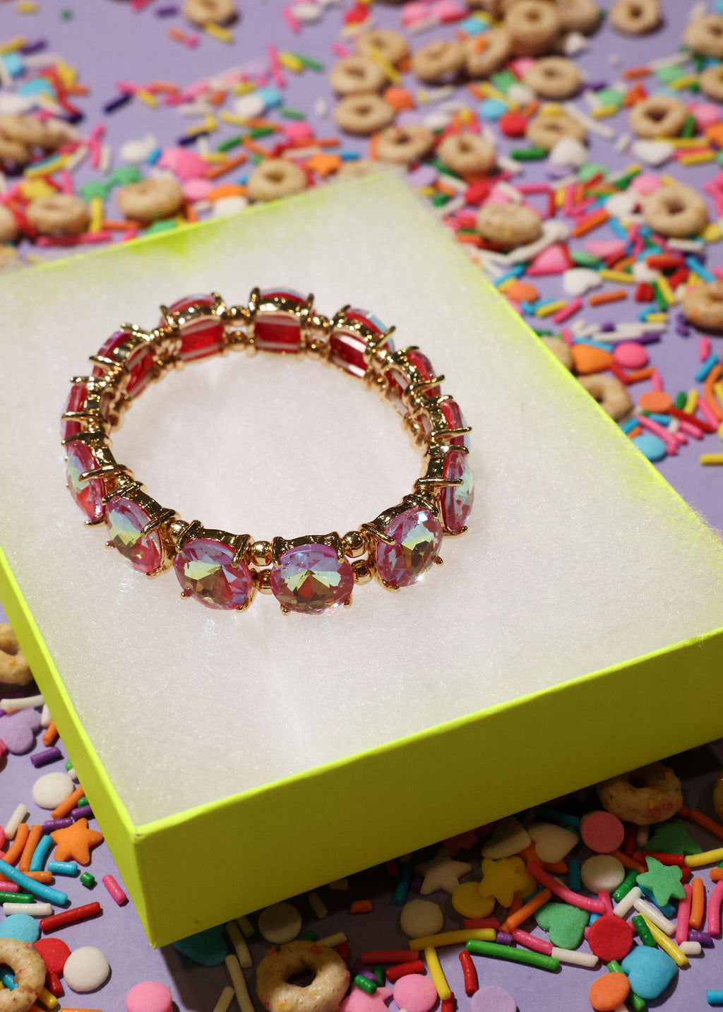 Colorful bracelet on a yellow box with colorful sprinkles in the background