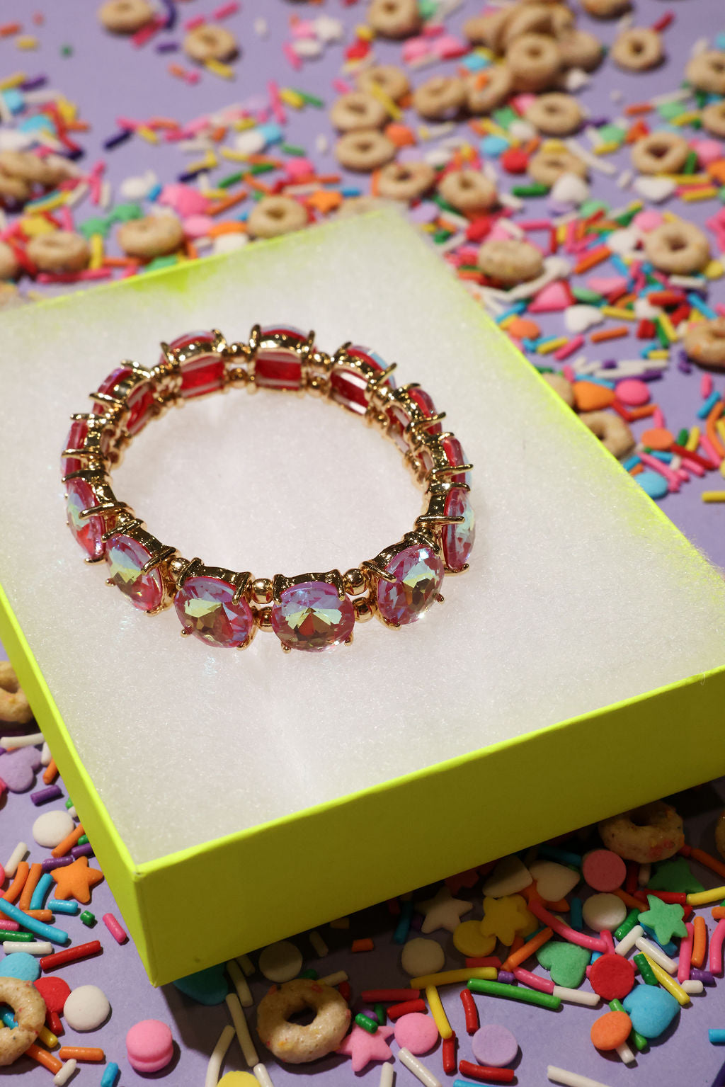 Colorful bracelet on a yellow box with colorful sprinkles in the background