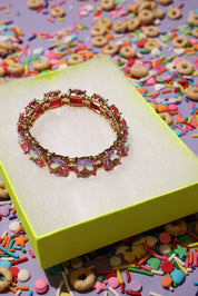 Colorful bracelet on a yellow box with colorful sprinkles in the background