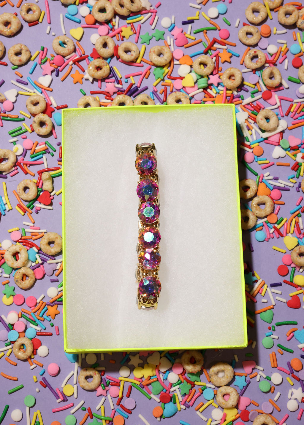Colorful bracelet on a yellow card with cereal and sprinkles in the background