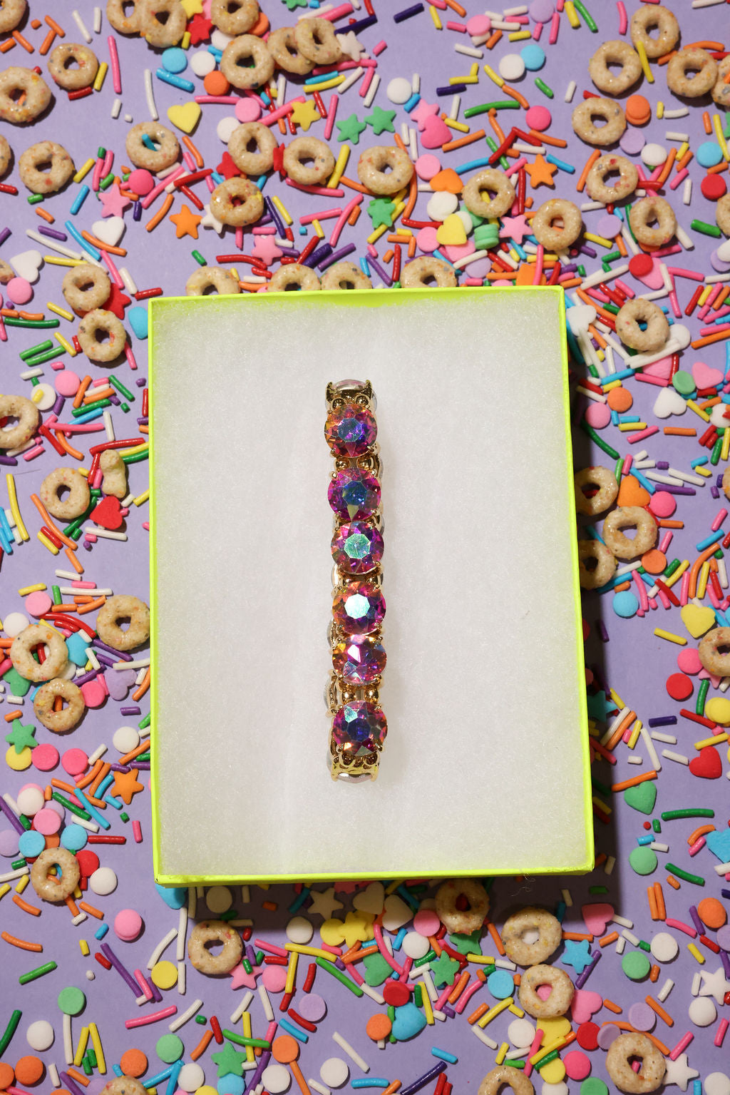 Colorful bracelet on a yellow card with cereal and sprinkles in the background
