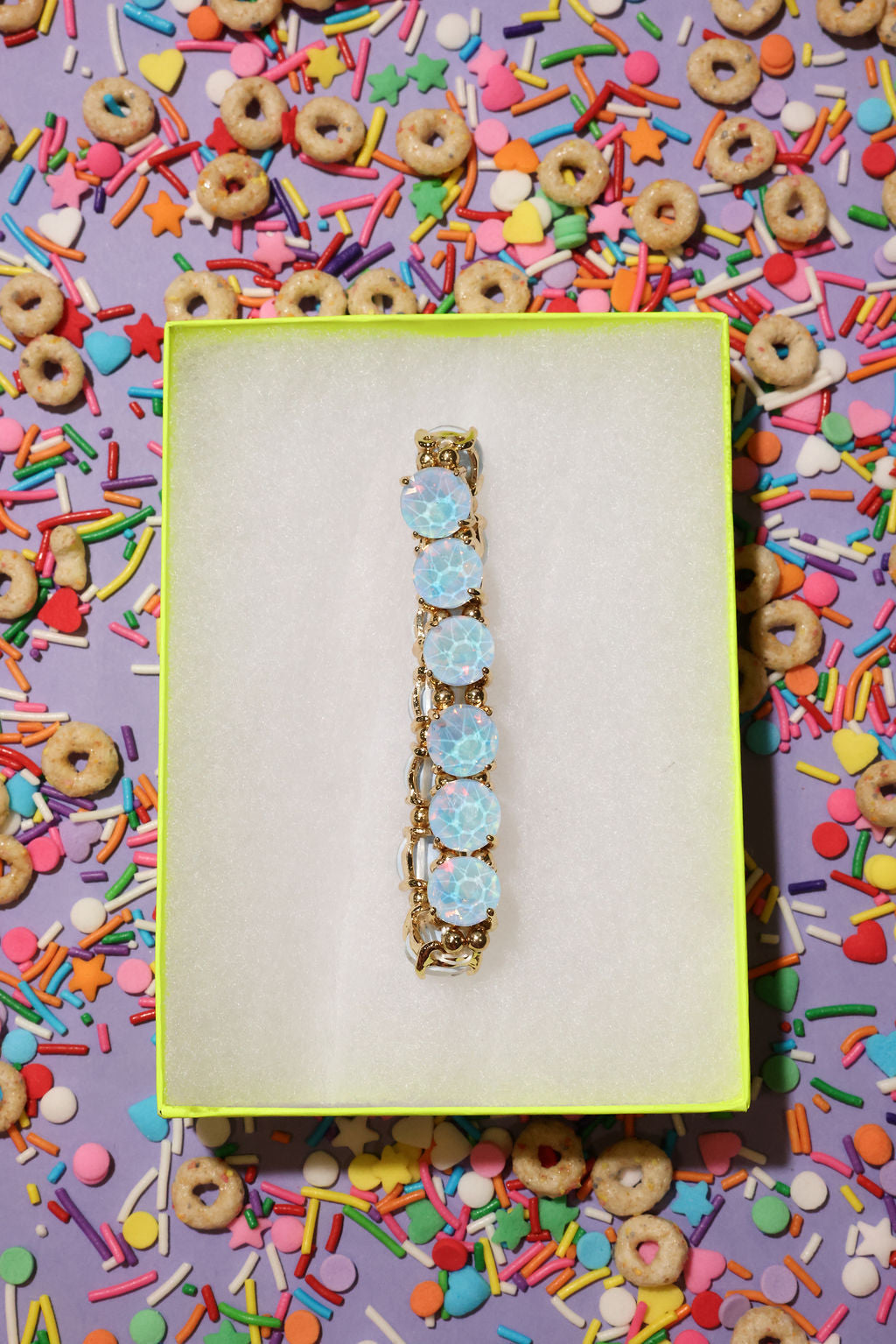 Decorative hair barrette with blue flowers on a colorful sprinkles background