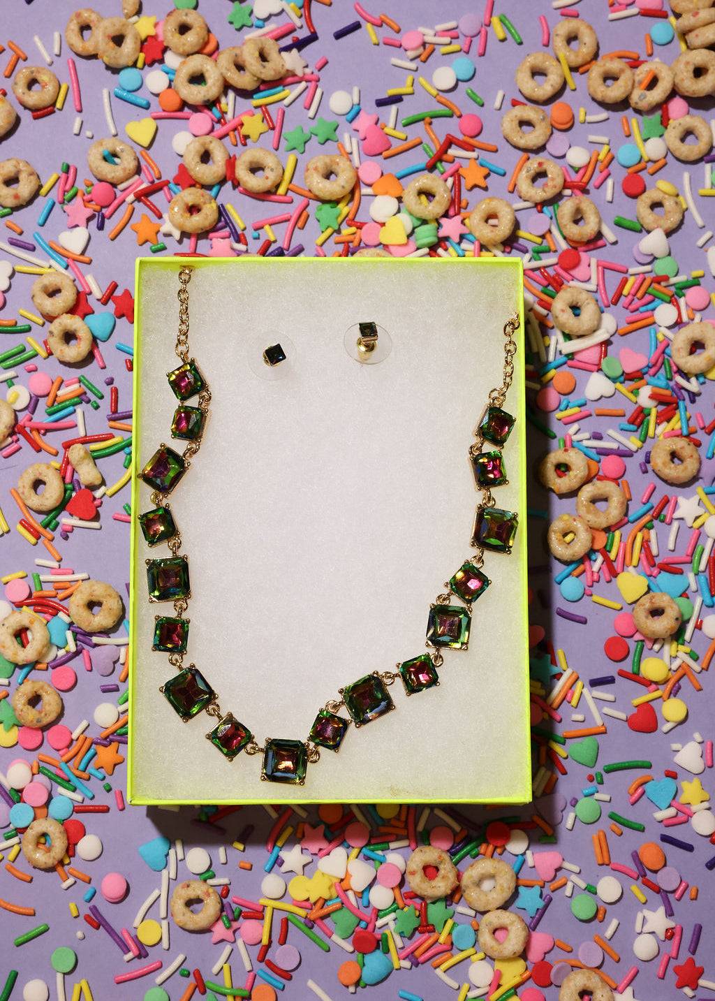 Necklace on a yellow card with colorful sprinkles and cereal pieces in the background