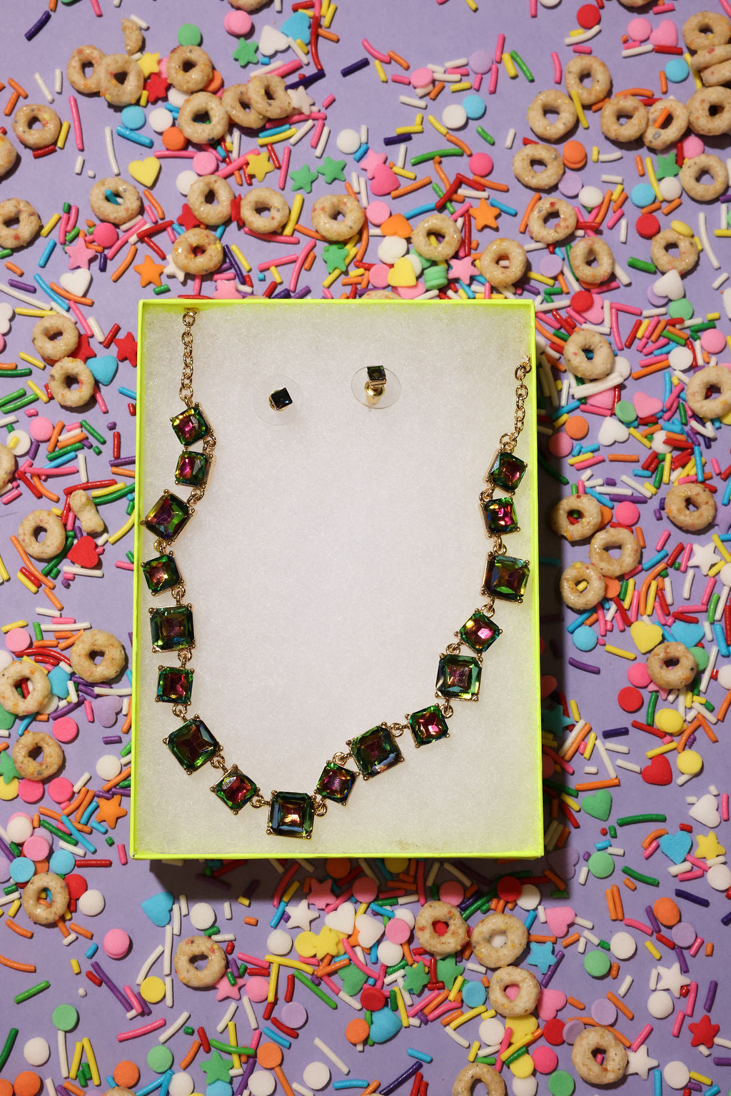 Necklace on a yellow card with colorful sprinkles and cereal pieces in the background
