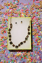 Necklace on a yellow card with colorful sprinkles and cereal pieces in the background