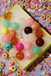Colorful beaded necklace in a box with a colorful background