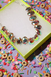Colorful beaded bracelet on a box with colorful sprinkles and cereal in the background