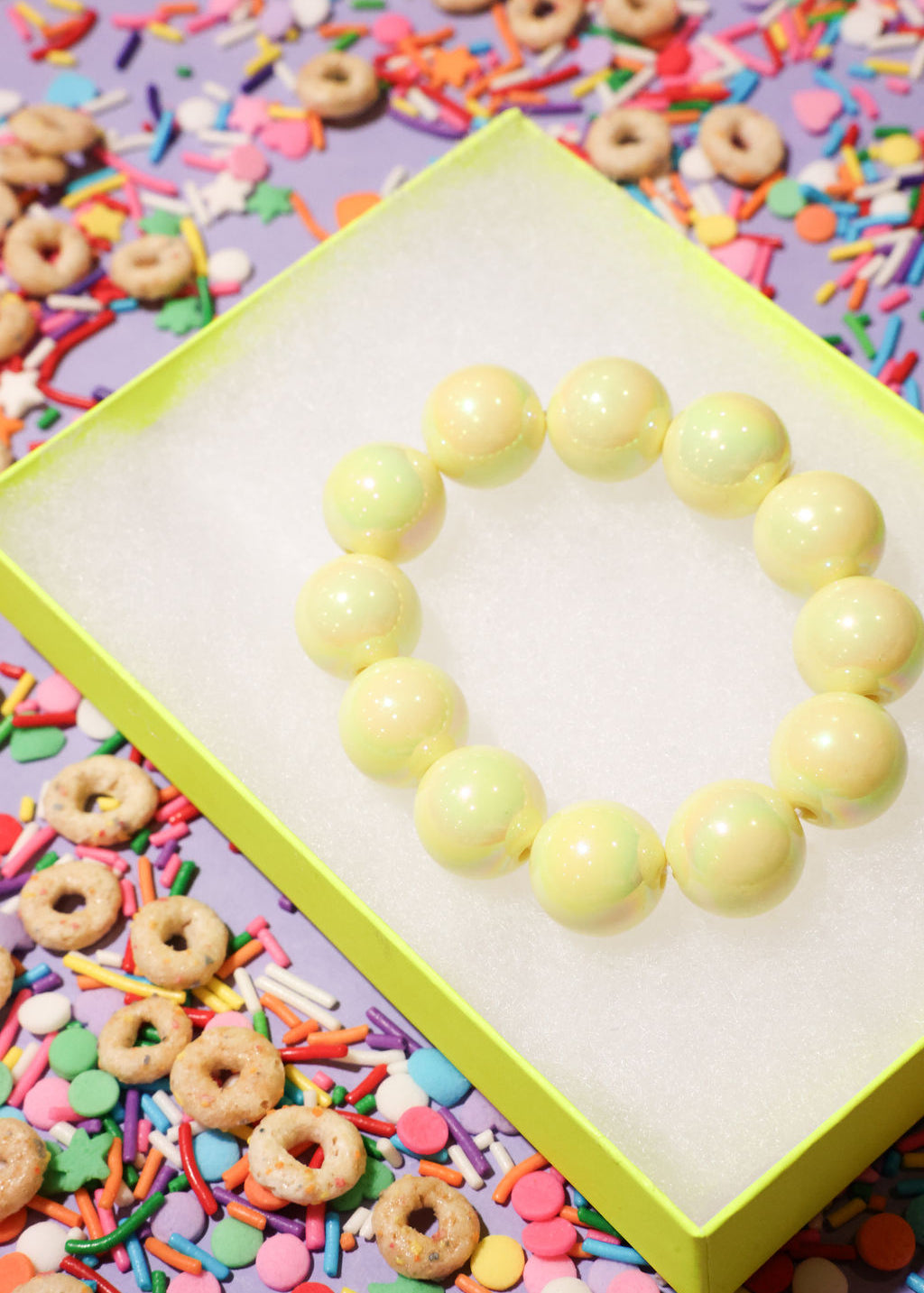 Yellow beaded heart on a colorful background with sprinkles and cereal