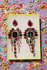Colorful rhinestone earrings on a yellow card with a colorful background of cereal and sprinkles