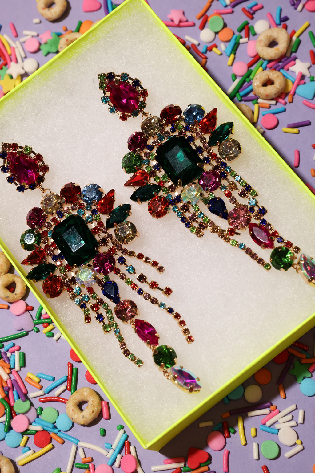 Colorful jeweled hair pins on a box with colorful sprinkles and cereal in the background