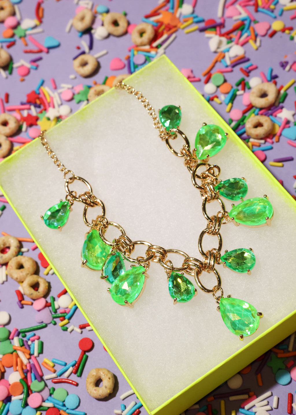 Necklace with green teardrop pendants on a colorful background