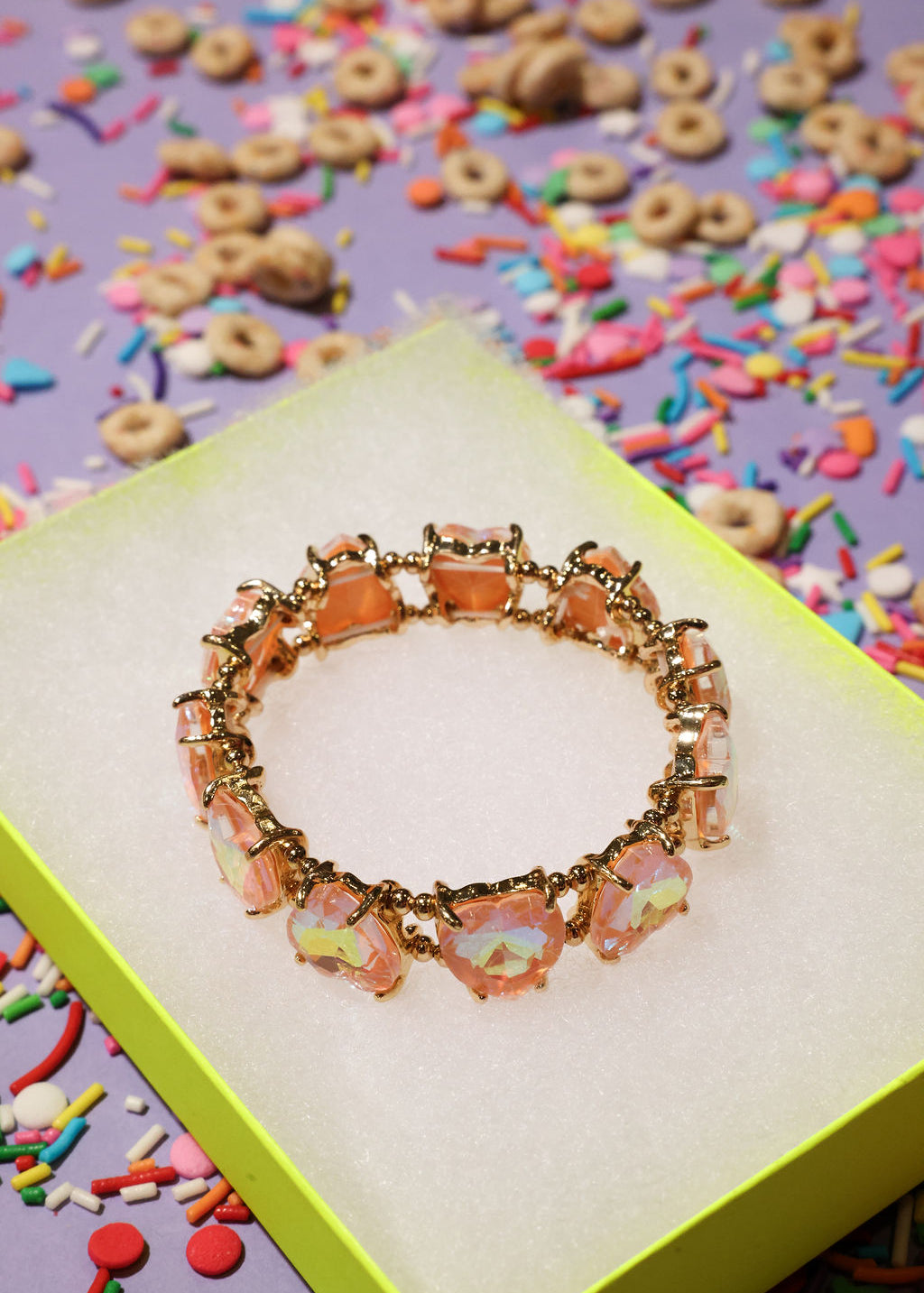 Bracelet with colorful charms on a box surrounded by cereal and sprinkles