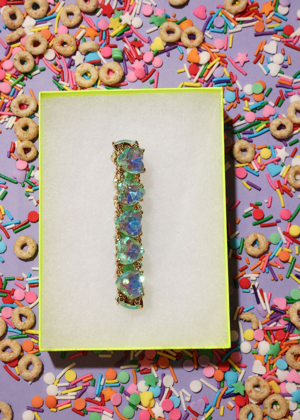 Decorative bracelet on a purple card with colorful cereal and sprinkles around