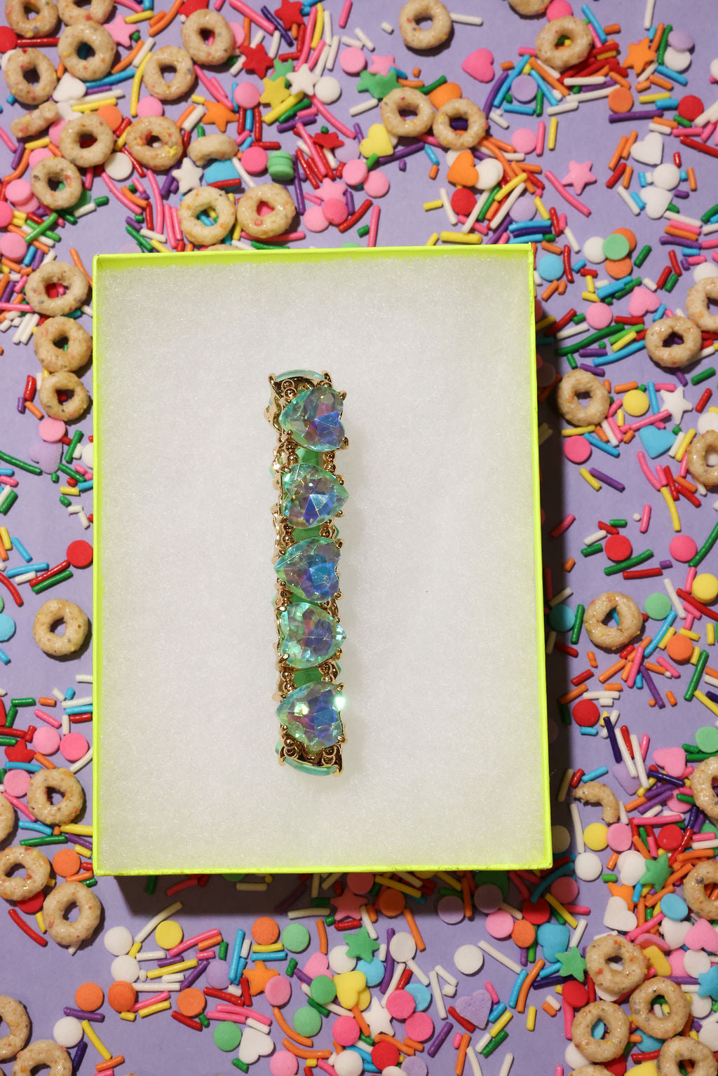 Decorative bracelet on a purple card with colorful cereal and sprinkles around