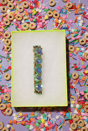 Decorative bracelet on a purple card with colorful cereal and sprinkles around